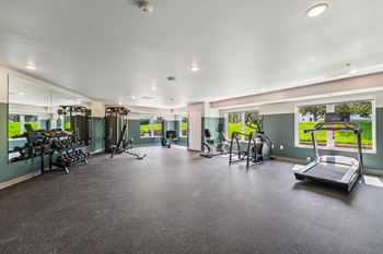 A spacious gym with treadmills, elliptical machines, and other exercise equipment.